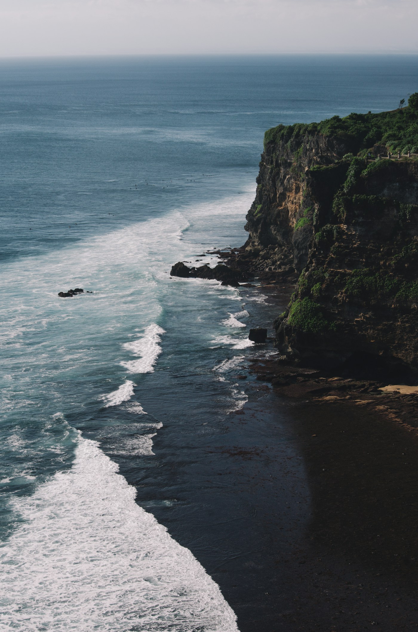 Green cliffs falling into deep blue ocean
